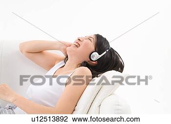 Stock Photo - young woman wearing 
headphones. fotosearch 
- search stock 
photos, pictures, 
images, and photo 
clipart