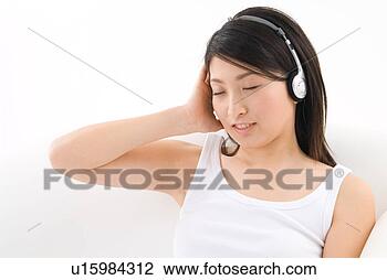 Stock Photo - young woman wearing 
headphones. fotosearch 
- search stock 
photos, pictures, 
images, and photo 
clipart