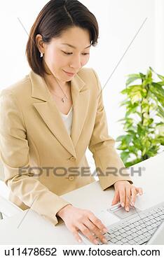 Stock Photo - a mid adult woman 
using computer. 
fotosearch - search 
stock photos, 
pictures, images, 
and photo clipart