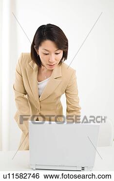 Stock Photo - a mid adult woman 
using computer. 
fotosearch - search 
stock photos, 
pictures, images, 
and photo clipart