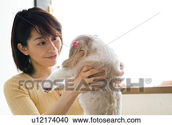 Stock Photography - a mid adult woman 
lifting a dog. 
fotosearch - search 
stock photos, 
pictures, images, 
and photo clipart