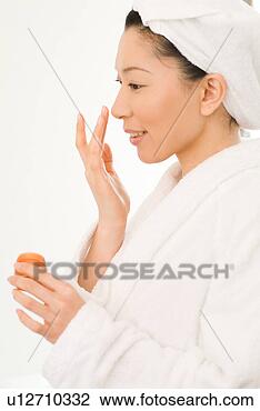 Stock Photo - a mid adult woman 
in bathrobe applying 
moisturizer. fotosearch 
- search stock 
photos, pictures, 
images, and photo 
clipart