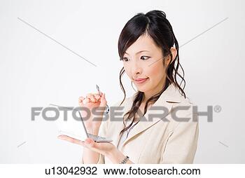 Stock Photo - a mid adult woman 
using electronic 
dictionary. fotosearch 
- search stock 
photos, pictures, 
images, and photo 
clipart