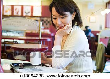 Stock Photo - a mid adult woman 
sitting in a coffee 
shop. fotosearch 
- search stock 
photos, pictures, 
images, and photo 
clipart