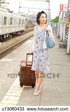 Stock Photo - a mid adult woman 
walking with suitcase. 
fotosearch - search 
stock photos, 
pictures, images, 
and photo clipart