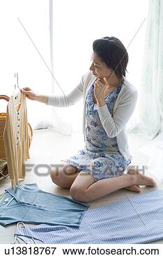 Picture - a mid adult woman 
selecting clothes. 
fotosearch - search 
stock photos, 
pictures, images, 
and photo clipart