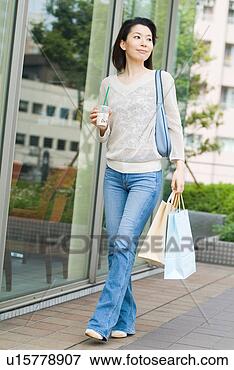 Picture - a mid adult woman 
walking with shopping 
bags. fotosearch 
- search stock 
photos, pictures, 
images, and photo 
clipart