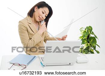 Stock Photo - a mid adult woman 
talking over phone. 
fotosearch - search 
stock photos, 
pictures, images, 
and photo clipart