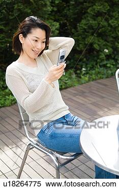 Stock Image - a mid adult woman 
looking at mobile 
phone. fotosearch 
- search stock 
photos, pictures, 
images, and photo 
clipart