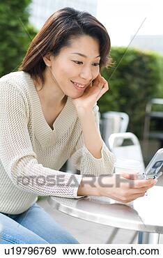 Stock Photograph - a mid adult woman 
looking at mobile 
phone. fotosearch 
- search stock 
photos, pictures, 
images, and photo 
clipart