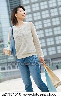 Stock Photography - a mid adult woman 
walking with shopping 
bags. fotosearch 
- search stock 
photos, pictures, 
images, and photo 
clipart