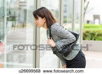 Stock Photo - a mid adult woman 
looking into shop 
window. fotosearch 
- search stock 
photos, pictures, 
images, and photo 
clipart