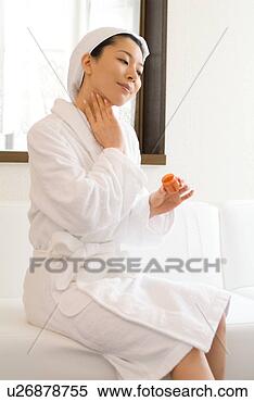 Stock Image - a mid adult woman 
in bathrobe applying 
moisturizer. fotosearch 
- search stock 
photos, pictures, 
images, and photo 
clipart