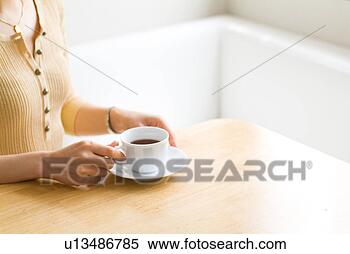 Stock Image - midsection of 
a woman drinking 
a cup of tea. 
fotosearch - search 
stock photos, 
pictures, images, 
and photo clipart