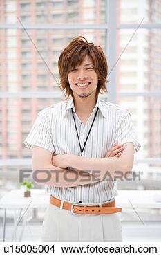 Stock Photo - portrait of young 
man standing in 
office. fotosearch 
- search stock 
photos, pictures, 
images, and photo 
clipart