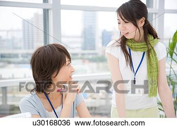 Stock Photo - two young women 
talking. fotosearch 
- search stock 
photos, pictures, 
images, and photo 
clipart