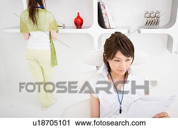 Stock Photography - a young woman 
reading document 
with a young woman 
standing behind. 
fotosearch - search 
stock photos, 
pictures, images, 
and photo clipart