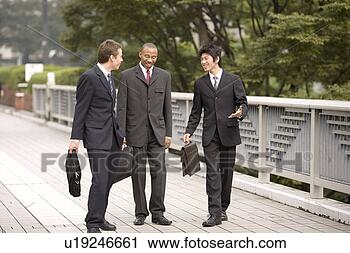 Stock Photography - three businessmen 
talking while 
walking. fotosearch 
- search stock 
photos, pictures, 
images, and photo 
clipart