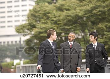 Stock Photography - three businessmen 
talking while 
walking. fotosearch 
- search stock 
photos, pictures, 
images, and photo 
clipart