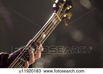 Stock Photo - young man playing 
bass guitar on 
stage. fotosearch 
- search stock 
photos, pictures, 
images, and photo 
clipart