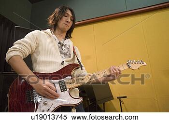 Stock Image - young man playing 
electric guitar. 
fotosearch - search 
stock photos, 
pictures, images, 
and photo clipart