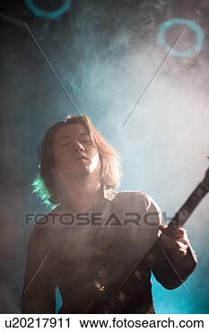 Stock Photography - young man playing 
bass guitar on 
stage. fotosearch 
- search stock 
photos, pictures, 
images, and photo 
clipart