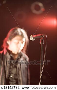 Stock Photo - young man standing 
in front of microphone. 
fotosearch - search 
stock photos, 
pictures, images, 
and photo clipart
