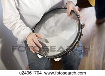 Stock Photo - young woman playing 
tambourine. fotosearch 
- search stock 
photos, pictures, 
images, and photo 
clipart