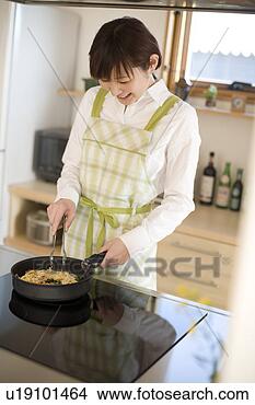 Stock Photo - young woman cooking 
spaghetti. fotosearch 
- search stock 
photos, pictures, 
images, and photo 
clipart