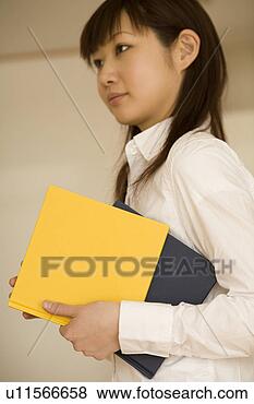 Stock Photo - young woman holding 
books. fotosearch 
- search stock 
photos, pictures, 
images, and photo 
clipart