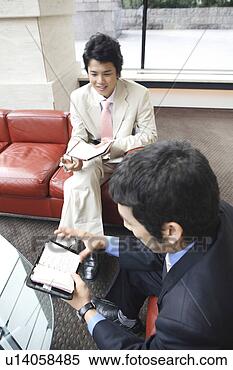 Stock Image - businessmen confirming 
the schedule. 
fotosearch - search 
stock photos, 
pictures, images, 
and photo clipart