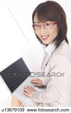 Stock Photograph - business lady 
who looks back 
hitting the laptop 
computer. fotosearch 
- search stock 
photos, pictures, 
images, and photo 
clipart