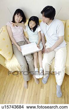Stock Photo - family which relaxes 
at the living 
room. fotosearch 
- search stock 
photos, pictures, 
images, and photo 
clipart