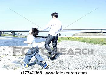 Stock Photo - parent and child 
who plays at the 
shore of the river. 
fotosearch - search 
stock photos, 
pictures, images, 
and photo clipart