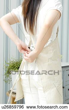 Stock Photo - woman putting 
on an apron. fotosearch 
- search stock 
photos, pictures, 
images, and photo 
clipart