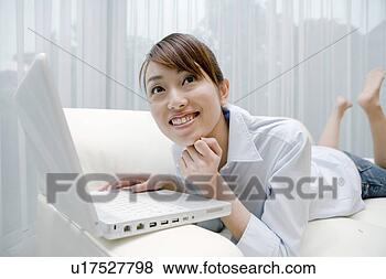 Stock Photo - woman who operates 
a pc in a sofa. 
fotosearch - search 
stock photos, 
pictures, images, 
and photo clipart