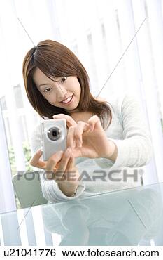 Stock Photo - woman who takes 
a photograph with 
a digital camera. 
fotosearch - search 
stock photos, 
pictures, images, 
and photo clipart