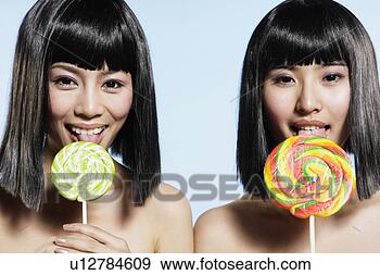 Stock Photograph - half-naked young 
women licking 
lollipops, smiling. 
fotosearch - search 
stock photos, 
pictures, images, 
and photo clipart