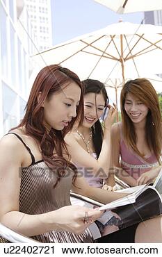 Stock Photography - three young women 
reading magazine 
under umbrella. 
fotosearch - search 
stock photos, 
pictures, images, 
and photo clipart