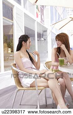 Picture - two young women 
sitting, chatting 
over beverage. 
fotosearch - search 
stock photos, 
pictures, images, 
and photo clipart
