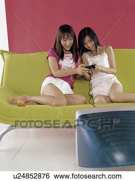 Stock Photo - two young women 
playing with video 
game in sofa. 
fotosearch - search 
stock photos, 
pictures, images, 
and photo clipart