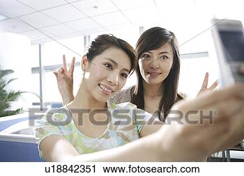 Stock Photography - women taking pictures 
in office. fotosearch 
- search stock 
photos, pictures, 
images, and photo 
clipart