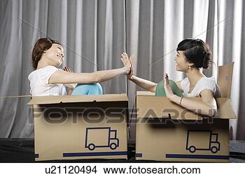 Stock Photo - young women sitting 
in box, playing. 
fotosearch - search 
stock photos, 
pictures, images, 
and photo clipart
