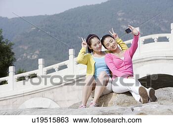 Stock Photo - young women taking 
photos near bridge. 
fotosearch - search 
stock photos, 
pictures, images, 
and photo clipart