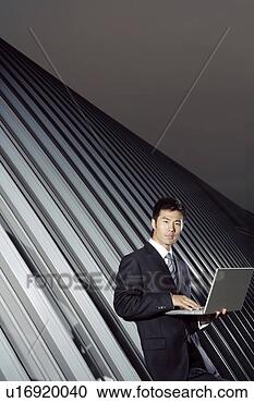 Stock Photography - business man tying 
on a laptop. fotosearch 
- search stock 
photos, pictures, 
images, and photo 
clipart