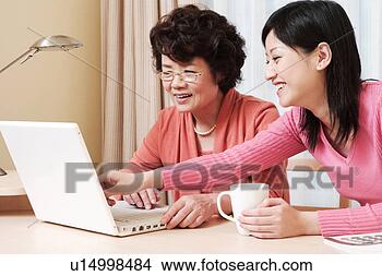 Stock Photo - daughter teaching 
mother how to 
use laptop. fotosearch 
- search stock 
photos, pictures, 
images, and photo 
clipart