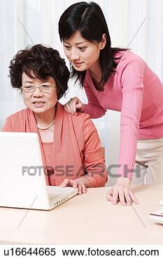 Stock Image - mother and daughter 
playing with laptop 
at desk. fotosearch 
- search stock 
photos, pictures, 
images, and photo 
clipart