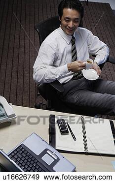 Stock Photograph - office man holding 
a tea cup on chair. 
fotosearch - search 
stock photos, 
pictures, images, 
and photo clipart