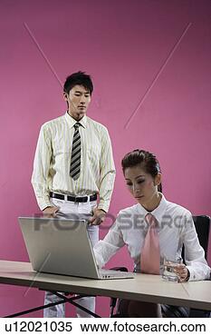 Stock Image - office young man 
and woman behind 
desk with a laptop. 
fotosearch - search 
stock photos, 
pictures, images, 
and photo clipart
