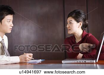 Picture - woman pointing 
at the laptop, 
man taking note. 
fotosearch - search 
stock photos, 
pictures, images, 
and photo clipart